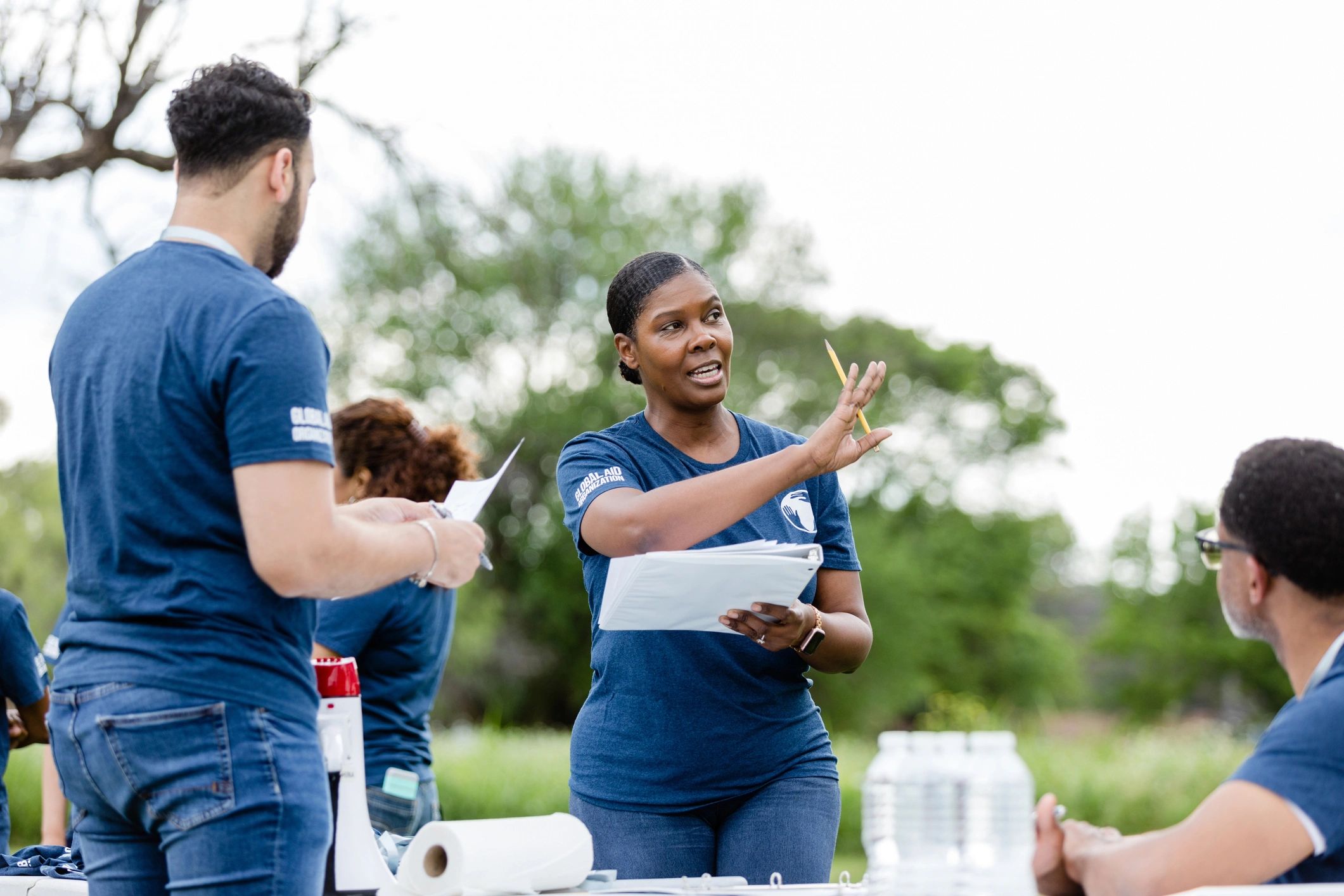 Volunteer leader pointing and organizing setup for an outdoor event