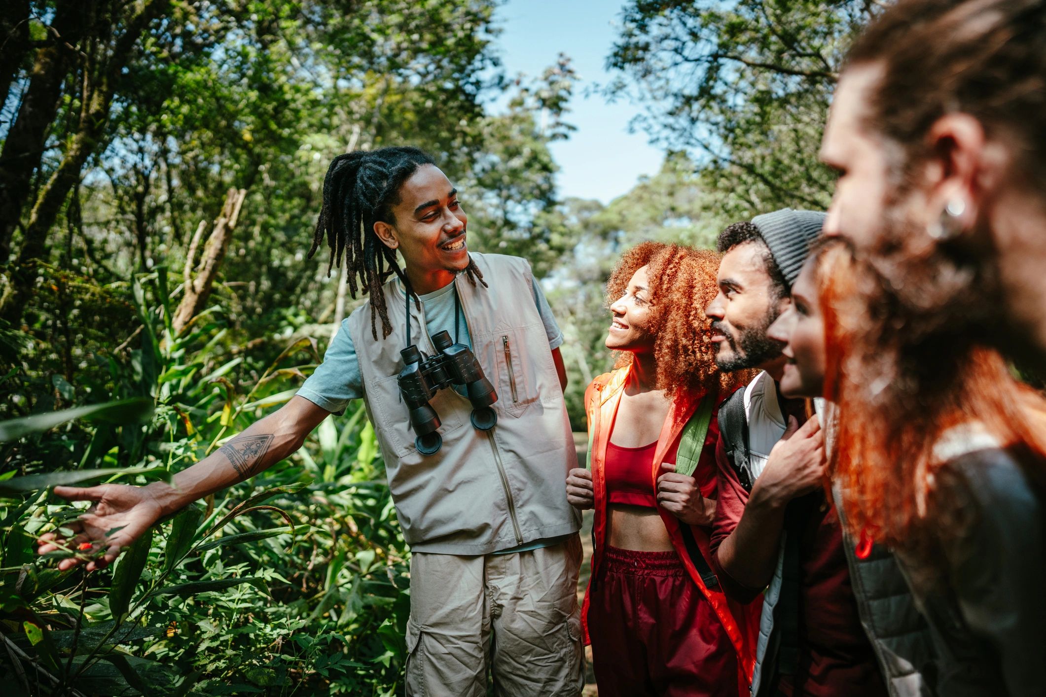 Group hiking in the forest while a guide points out plants