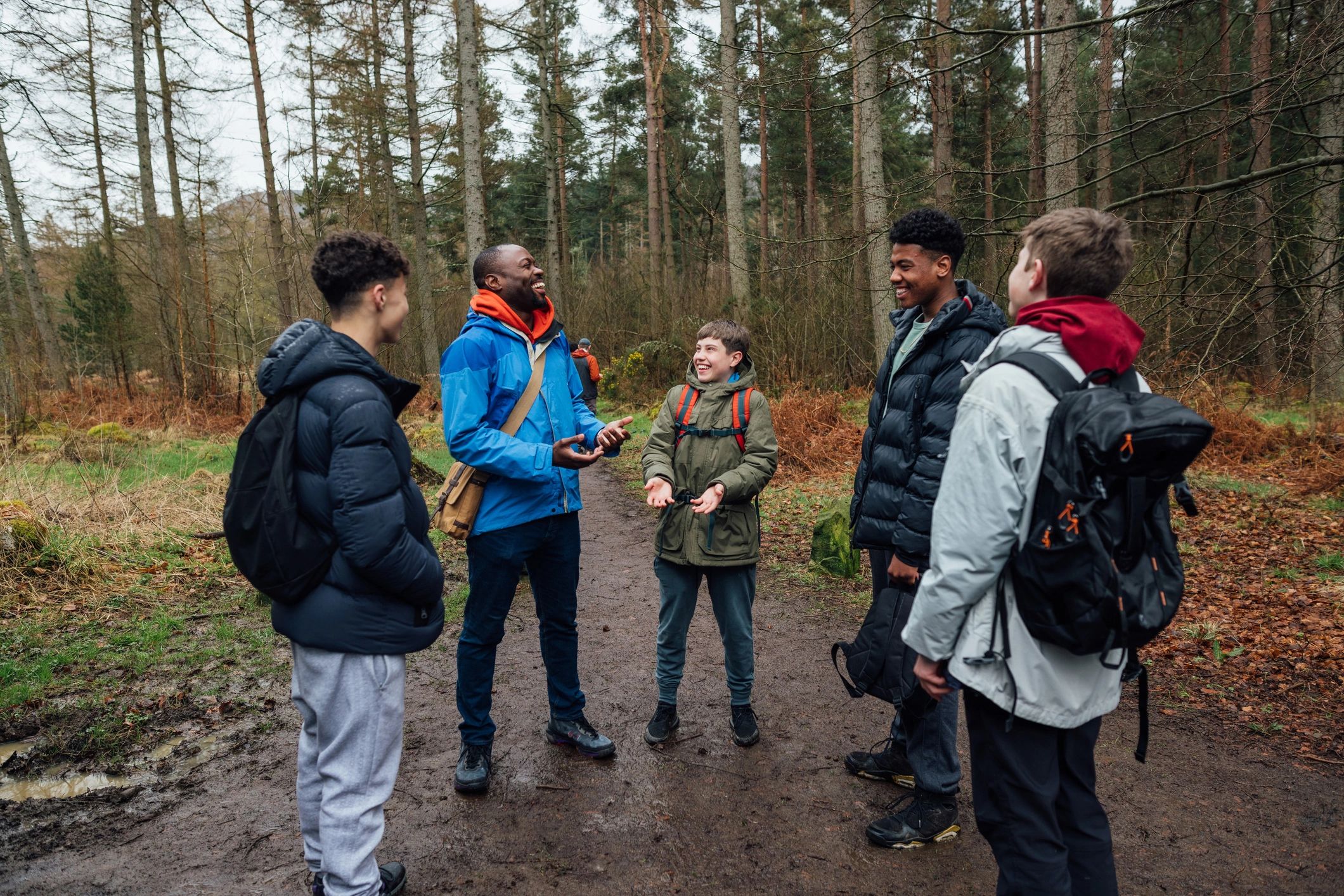Leader and teens talking outdoors during a group activity