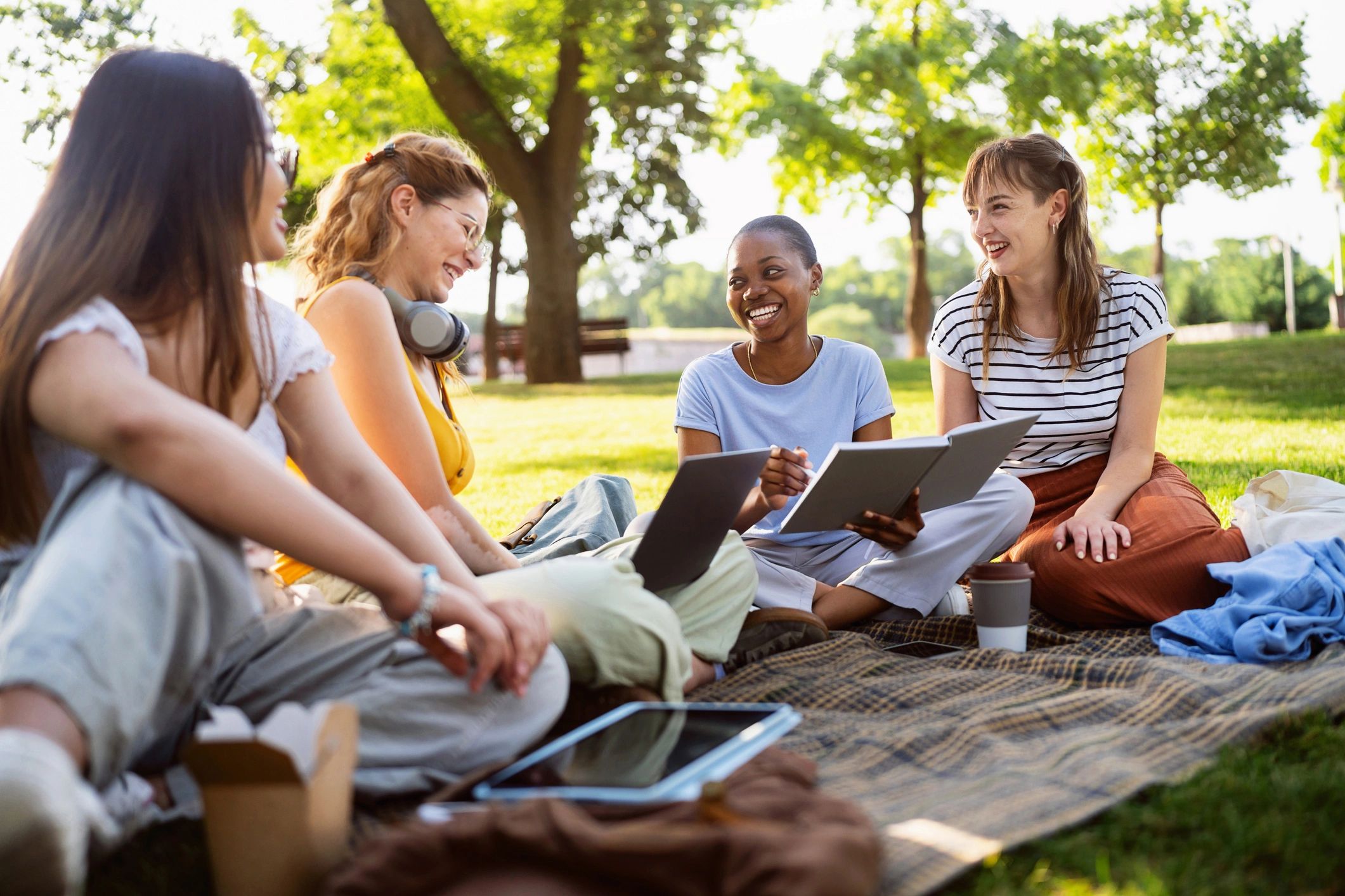 People working together outdoors with notebooks and materials